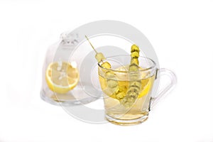 Hot tea with sage and lemon in a glass mug.