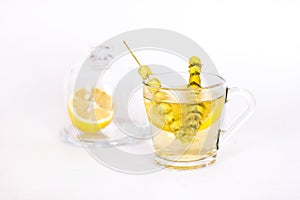 Hot tea with sage and lemon in a glass mug.