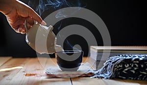 Hot tea in teapot and cup on wood table,