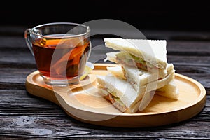 Hot Tea with Tuna Sandwich on wooden plate