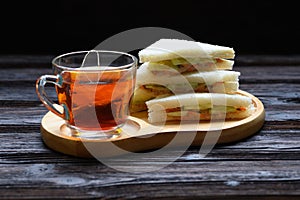 Hot Tea with Tuna Sandwich on wooden plate