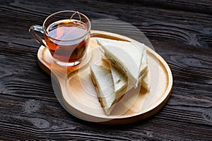 Hot Tea with Tuna Sandwich on wooden plate