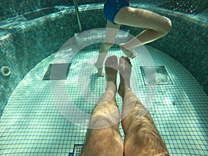 Hot tub pool, underwater shot of father and son legs in water