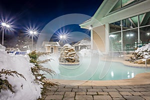 Hot tubs and ingound heated pool at a mountain village in winter