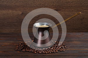 Hot turkish coffee pot and beans on wooden table