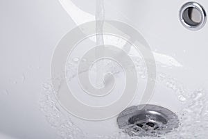 Hot water flows from the tap, into a white sink