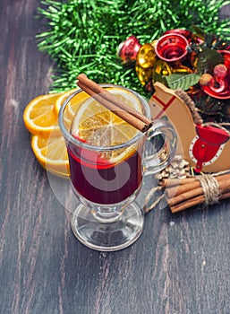 Hot wine (mulled wine) with spices on wooden background.