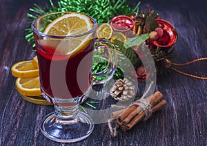 Hot wine (mulled wine) with spices on wooden background.