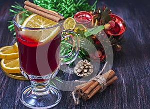 Hot wine (mulled wine) with spices on wooden background.