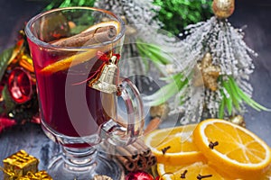 Hot wine (mulled wine) with spices on wooden background.