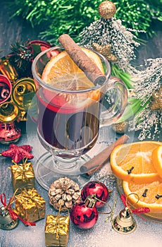 Hot wine (mulled wine) with spices on wooden background.