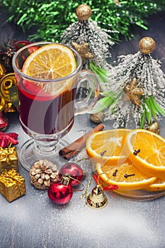 Hot wine (mulled wine) with spices on wooden background.