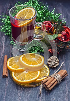 Hot wine (mulled wine) with spices on wooden background.