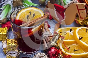 Hot wine (mulled wine) with spices on wooden background.