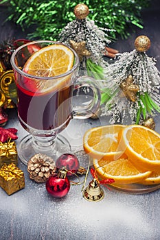 Hot wine (mulled wine) with spices on wooden background.