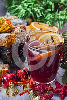 Hot wine (mulled wine) with spices on wooden background.