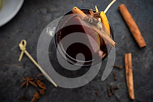 Hot winter Christmas drink in a glass mug: mulled wine with cinnamon, Apple, lemon and spices