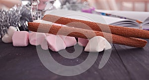 Hot winter drink with candies, Christmas or New Year decorations, dark background, rustic style, colored marshmallows