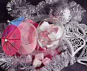 Hot winter drink with candies, Christmas or New Year decorations, dark background, rustic style, colored marshmallows