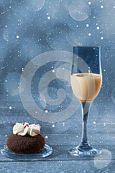 Hot winter drink with milk, eggs and dark rum in a glass on a dark blue background with bokeh