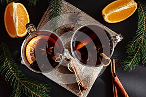Hot winter drinks. Two glasses of mulled wine with cinnamon and oranges on a festive Christmas background. Flat lay, top view,