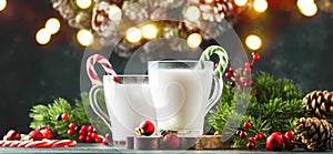 Hot winter white drink with candy sticks, Christmas or New Year decorations, dark background, rustic style, copy space