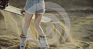 Hot woman lifting up a sandboard and sand falling down. Sport, tourism, lifestyle, commercial, advertisement concept