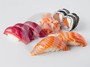 Hotate Sushi Roll and salmon and otoro sashimi with a white backdrop. Sushi with salmon and cucumber on a plate.?