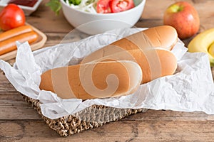 Hotdog bun in wood basket.