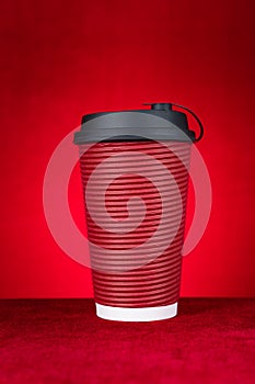 A hotdrink paper cup on a red background vertical composition