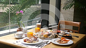 Hotel breakfast. Table near panoramic window with various food from buffet