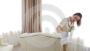 Hotel cleaning. Soft furniture surface is cleaned by pretty maid with wipe in hands. woman removing dirty stain from