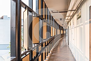 Hotel corridor with black steel and wooden plate with orange light that cast shadow on the white wall in Chiang Mai, Thailand