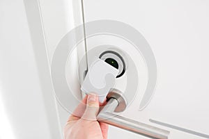 Hotel door - Young man holding a keycard in front of the electronic sensor of a room door. Concept travel or business