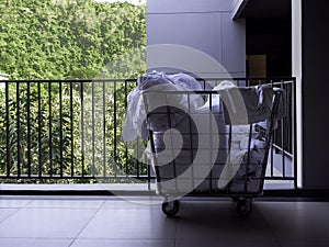 Hotel housekeeping maid laundry trolley with white used bed sheets.