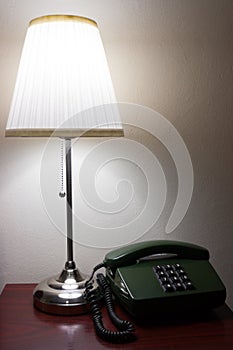 Hotel lamp and a telephone on reddish furniture