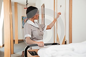 Hotel maid knocking on the hotel door for room service