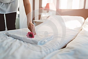 Hotel maid making a bed