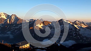 A hotel in the mountains illuminated by the setting sun