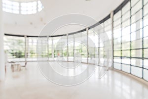 Hotel or office building lobby blur background interior view toward reception hall, modern luxury white room space with blurry