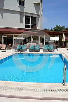 Hotel pool with chairs, veranda and swings