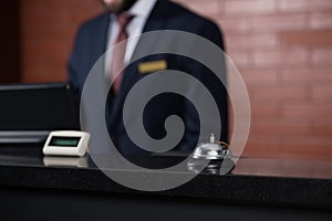 hotel reception desk with bell and blurred receptionist