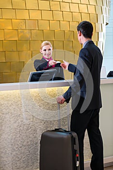 Hotel receptionist check in man giving key card