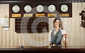 Hotel receptionist at counter desk with card