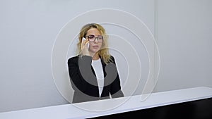 Hotel receptionist talking on phone with guests