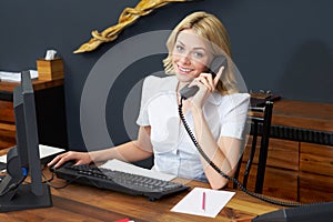 Hotel Receptionist Using Computer And Phone