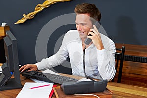 Hotel Receptionist Working At Computer