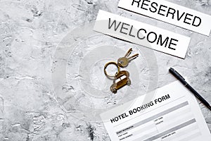 Hotel reservation blank and keys on stone background top view mockup