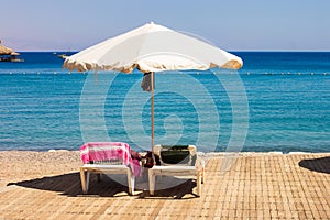 Hotel resort area beach deck chair and umbrella lunge furniture summer time vacation season concept scenic view on Red sea