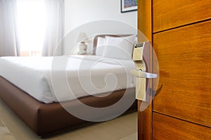 Hotel room ,Condominium or apartment doorway with open door in front of blur bedroom background, Copy space image or text